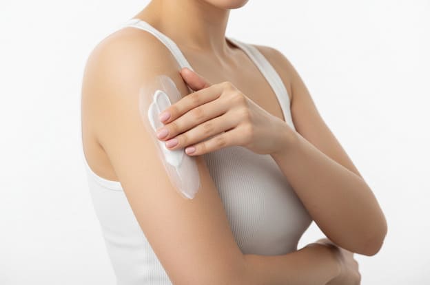 Femme appliquant crème corps Avon